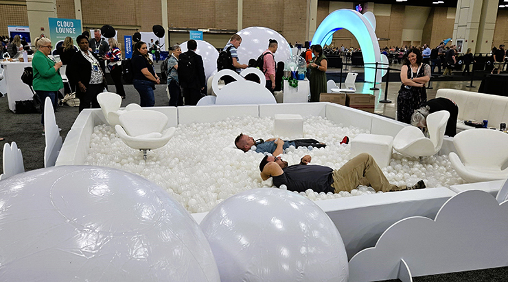 Floating in the “cloud” ball pit at the AWS Cloud Lounge while other attendees wait in line for cotton candy